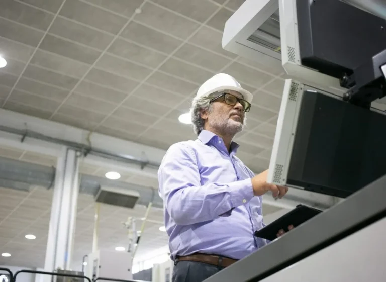 focused male plant engineer hardhat glasses operating industrial machine pushing buttons control panel 74855 16376
